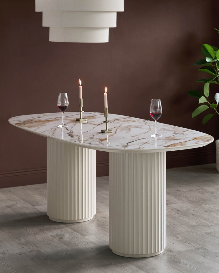 A marble-topped dining table with two ridged cylindrical legs, decorated with wine glasses and candles.