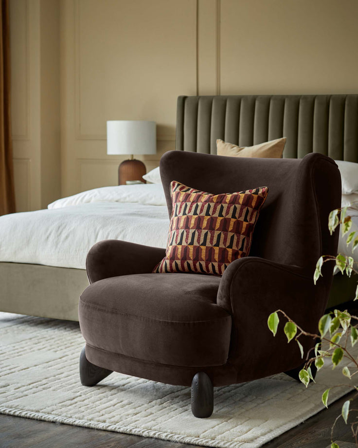 A brown wingback chair with patterned cushion sits on a textured rug in a bedroom setting.