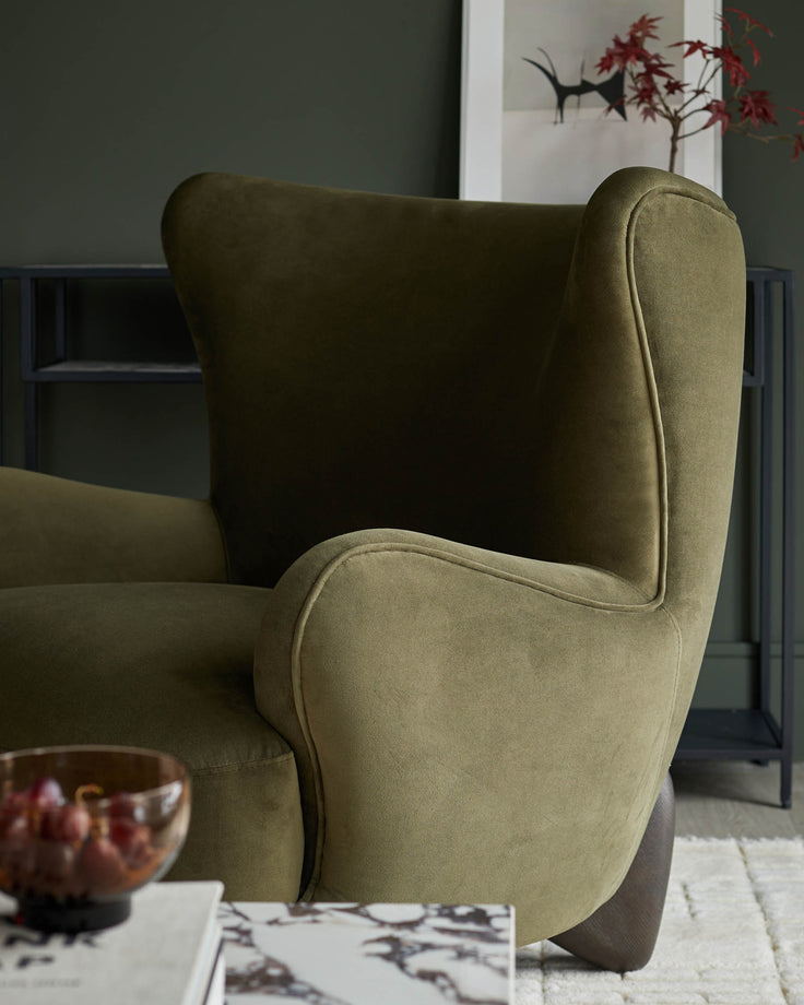Close-up of a stylish olive-green armchair, showcasing its curved armrest and cosy design, perfect for a modern living space.