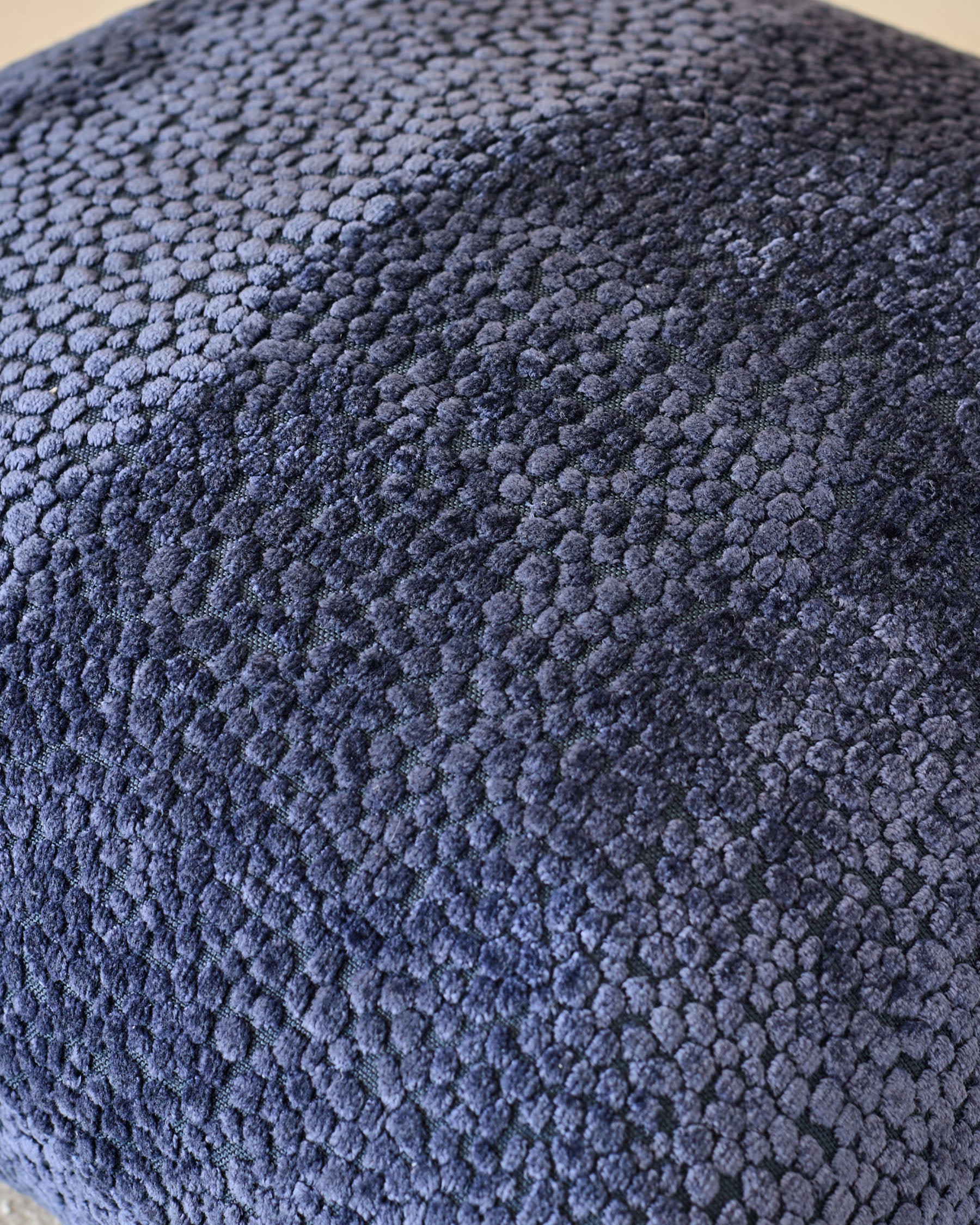 Close-up of navy Harlene cushion medium showing textured fabric surface with knitted pattern detail.