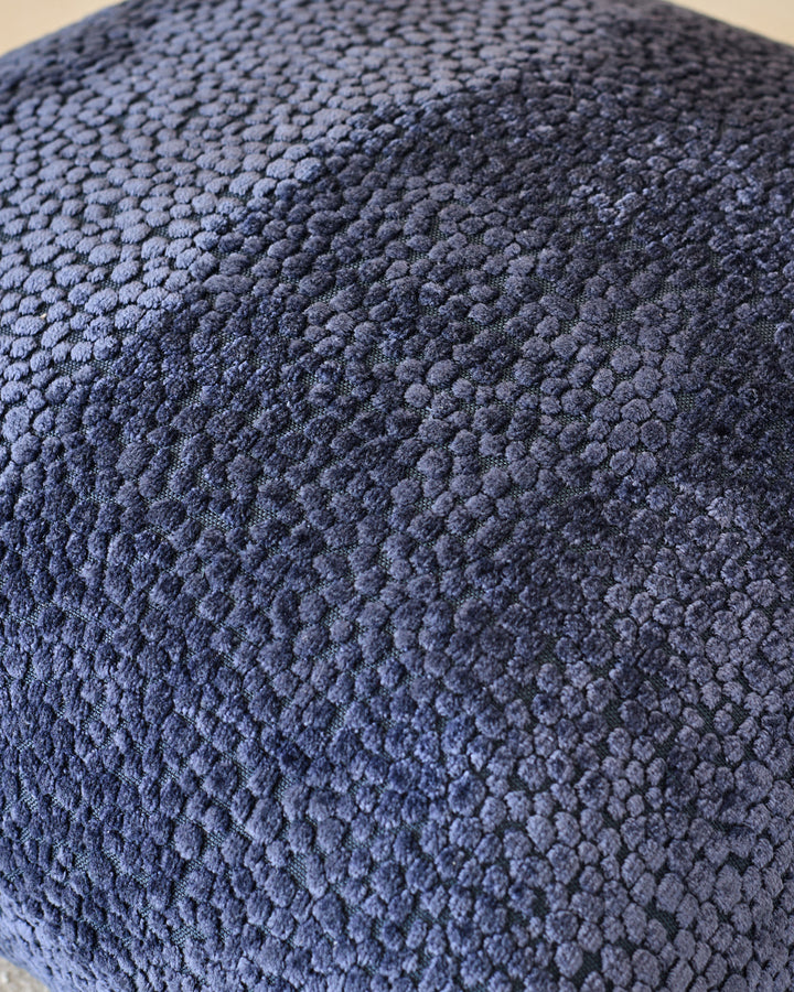 Close-up of navy Harlene cushion medium showing textured fabric surface with knitted pattern detail.