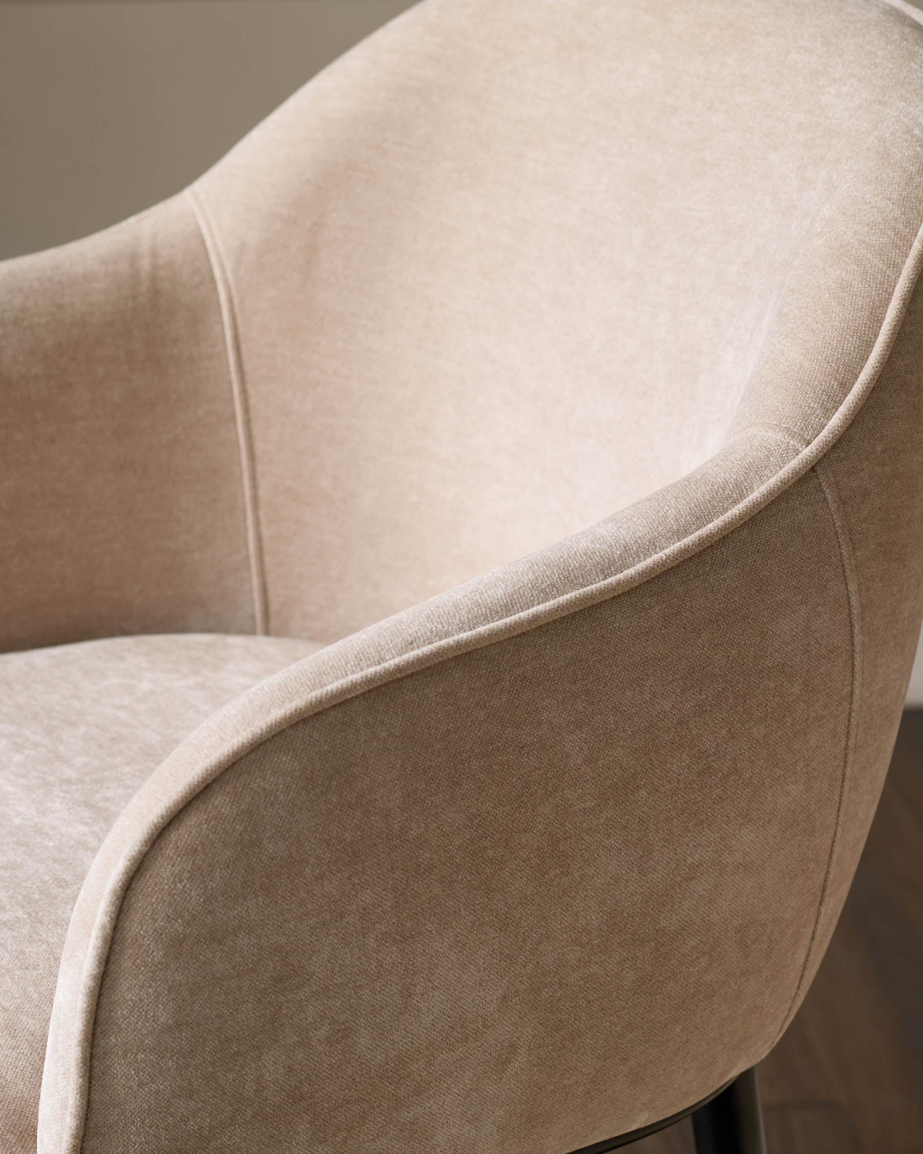 Harley bar stool in champagne fabric, close-up side view showing curved armrest and seat upholstery detail.