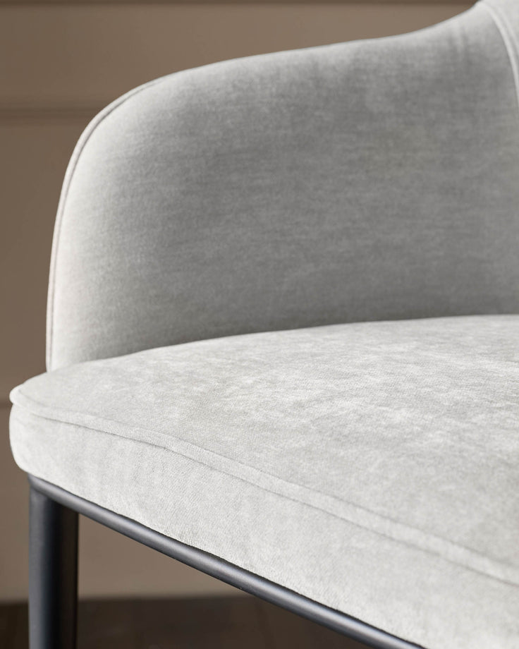 Harley bar stool in natural grey fabric, showing curved backrest and seat detail with dark metal base.
