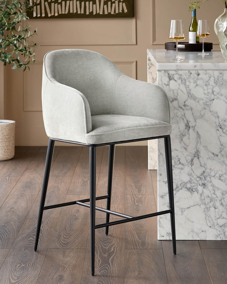 Harley bar stool in natural grey fabric with black metal legs, shown in a modern kitchen setting beside a marble countertop.