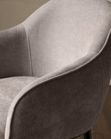 Harley bar stool in mocha fabric, close-up detail of curved armrest and seat cushioning from side angle.