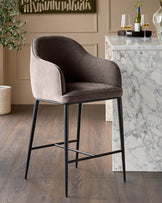 Mocha fabric bar stool with curved back and black metal legs, positioned at a marble counter in a modern dining setting.