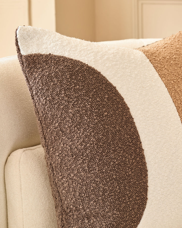 Harmony Cushion Medium in Natural, showing textured brown and cream striped boucle fabric on a cream upholstered sofa.