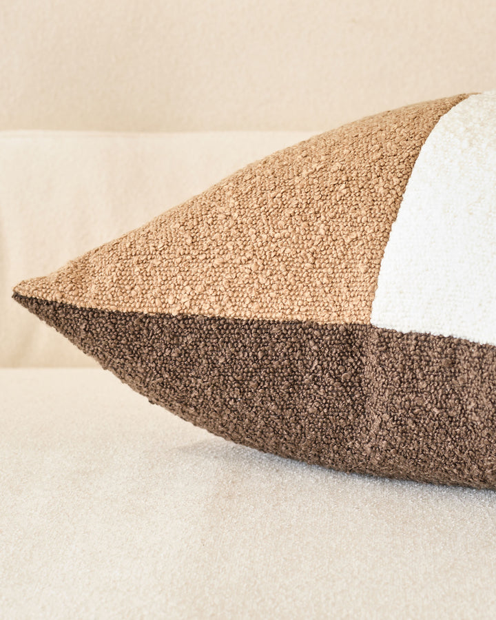 Harmony Cushion Medium in natural tones, showing layered textured fabrics in beige and brown with white piping detail.