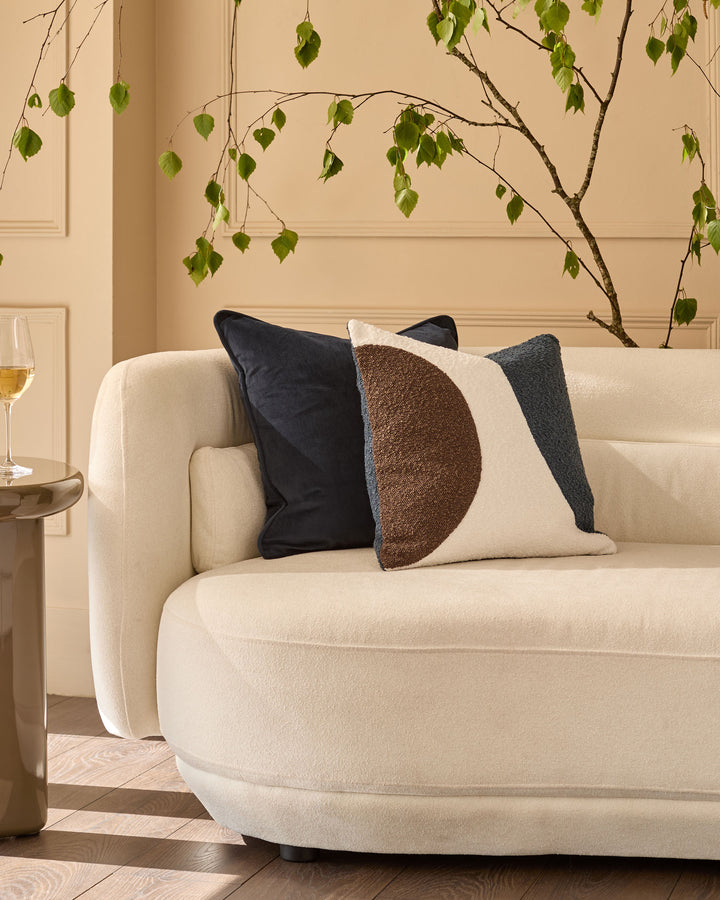 Luca large navy cushion on cream sofa with geometric brown and cream design, styled in modern living room.
