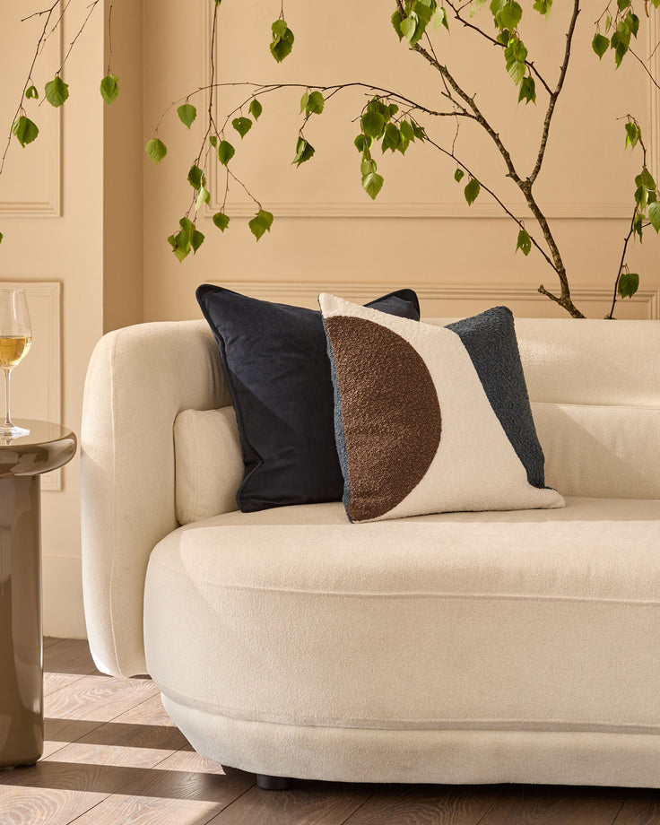 Luca large navy cushion on cream sofa with geometric brown and cream design, styled in modern living room.