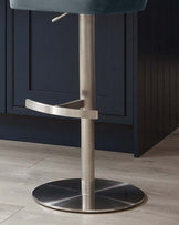 Harper velvet gas lift bar stool in blue-grey with brushed stainless steel base and curved footrest.