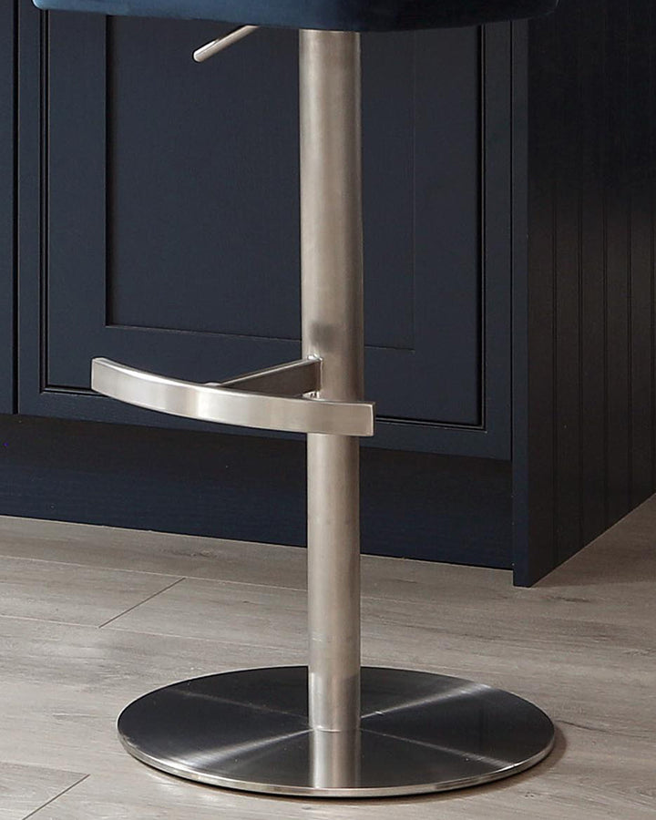 Harper velvet gas lift bar stool in dark blue with brushed stainless steel base and footrest, shown from front angle.