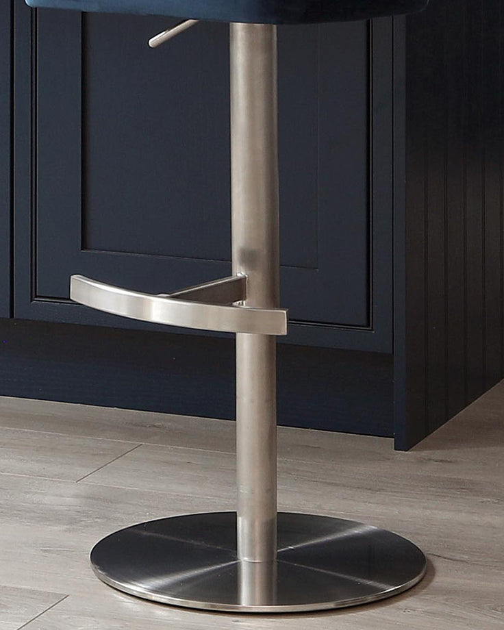 Harper velvet gas lift bar stool in dark blue with brushed stainless steel base and footrest, shown from front angle.