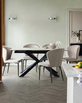 Harper dining chair in champagne velvet with black metal legs, shown in a modern dining room setting.