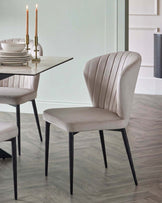 Harper dining chair in champagne velvet with black metal legs, shown in modern dining setting.