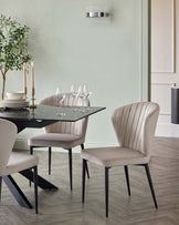 Harper dining chair in champagne velvet with black metal legs, shown in dining room setting.