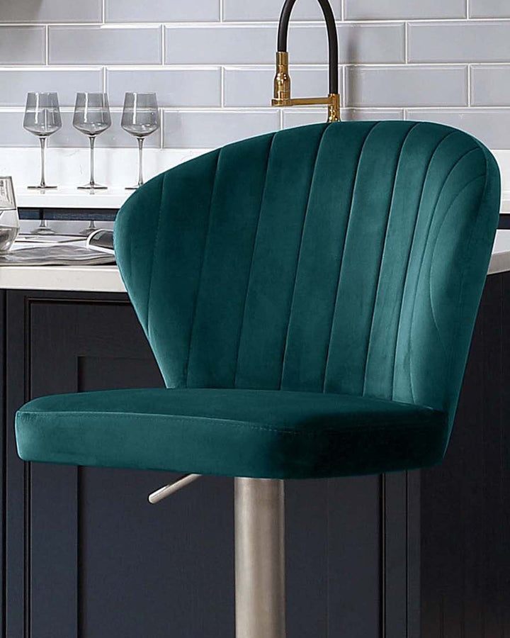 Harper velvet gas lift bar stool in dark teal with vertical channel stitching and chrome base, shown at kitchen island.