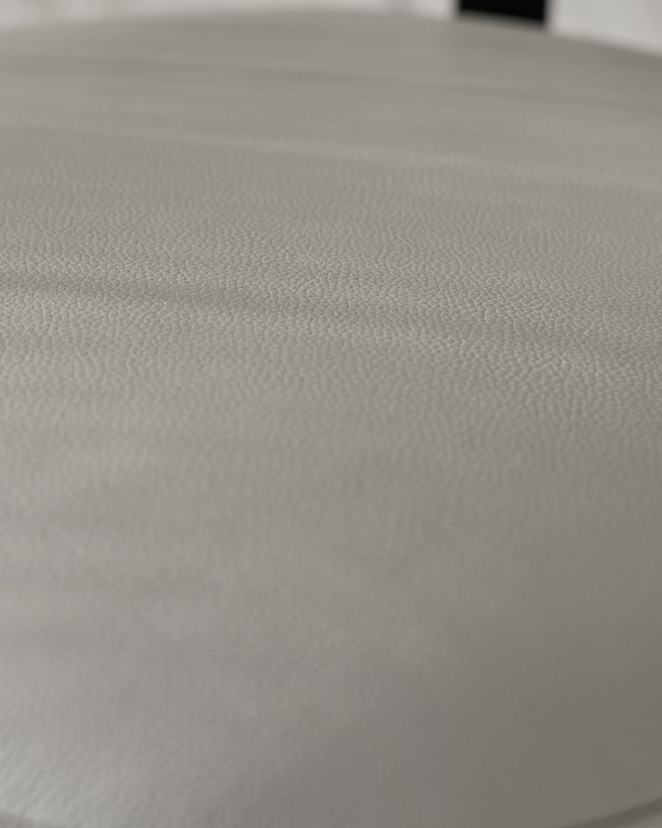 Close-up of a textured grey stool top. Minimalist design ideal for modern interiors.