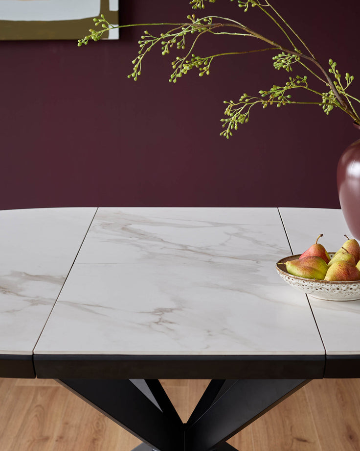 A modern dining table with a white, marble-effect top, and striking black base. Perfect for contemporary dining spaces.