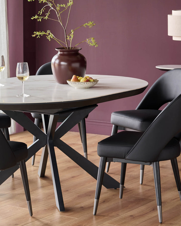 A round dining table with a marble effect top and black chairs with metal tipped legs are on display.