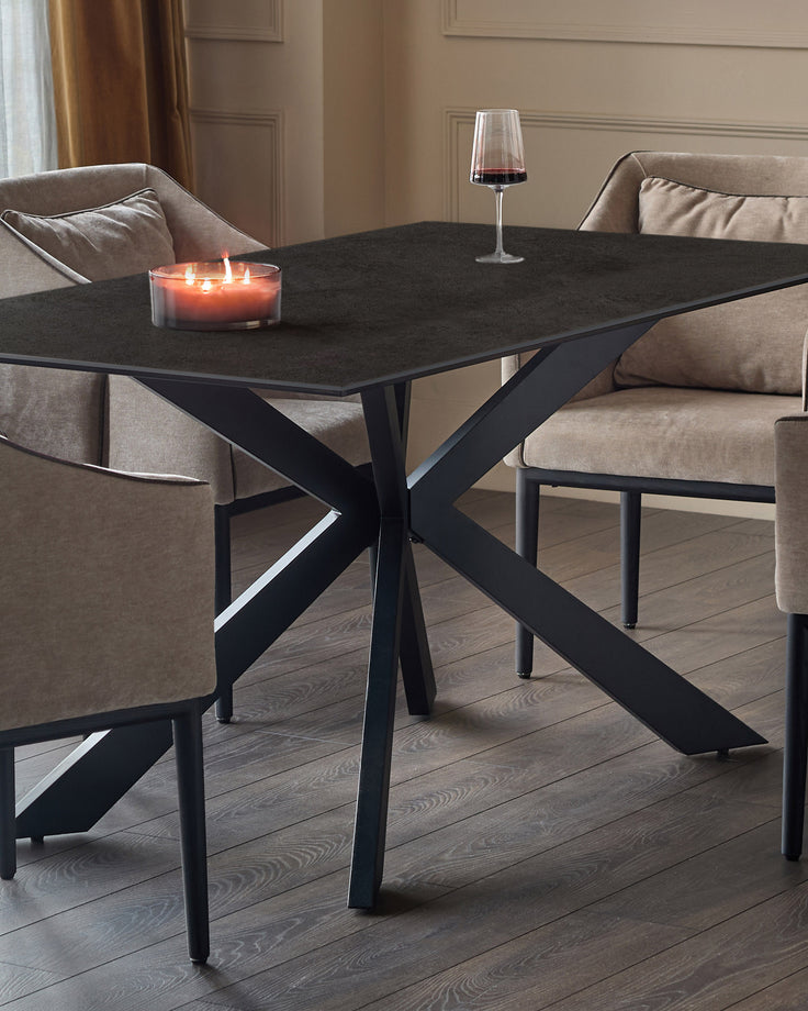 Hayden 6-seater dining table with dark grey ceramic top and black metal X-frame base, styled with chairs and decor.