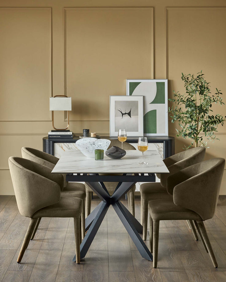 A dining set featuring a marble-topped table with a striking metal base, paired with four upholstered chairs.