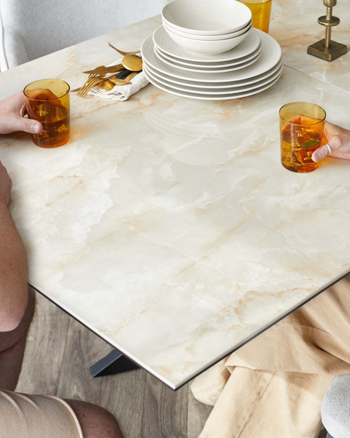 Elegant dining table with a marble-effect tabletop and sleek metal edges, capturing a modern yet timeless aesthetic.