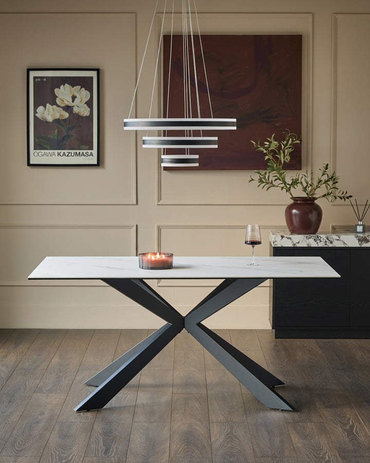 Hayden 6-seater dining table with white ceramic top and black X-frame base in modern dining room setting.