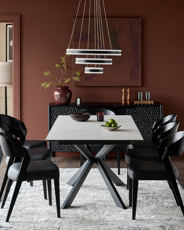 Hayden extending dining table in ceramic white with black metal X-frame base, styled in modern dining room setting.