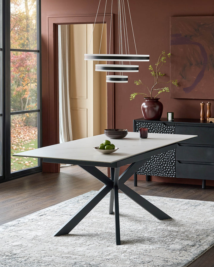 Hayden extending dining table with white ceramic top and black metal X-frame base in modern dining room setting.