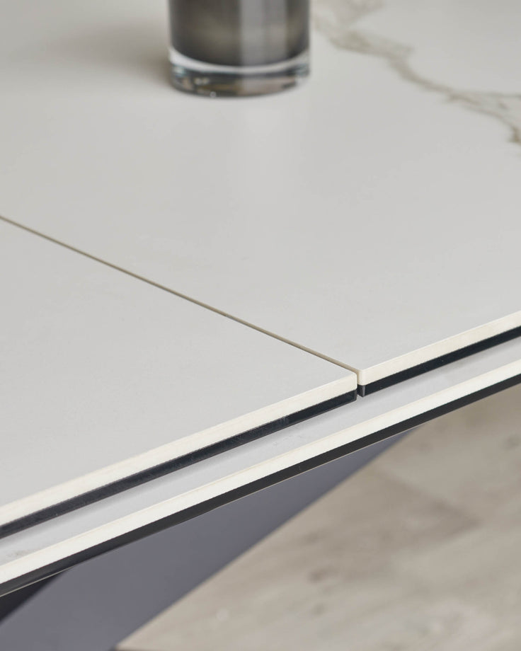 Close-up of a white and grey extendable dining table with a sleek, modern design, perfect for a contemporary dining space.