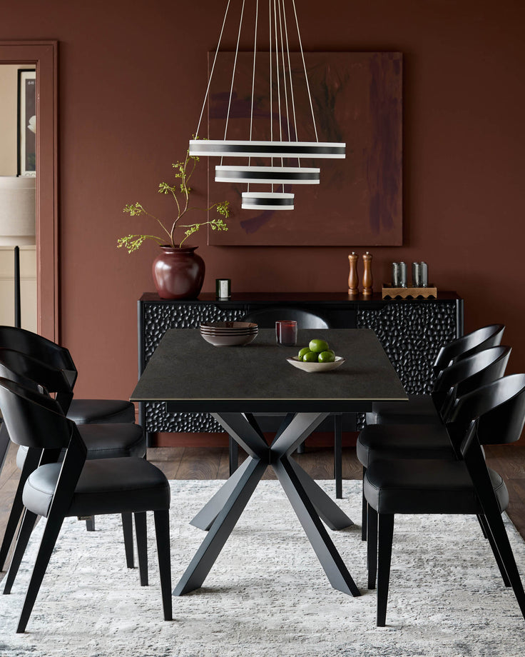 Hayden extending dining table in dark grey ceramic with black X-frame base, styled in modern dining room setting.