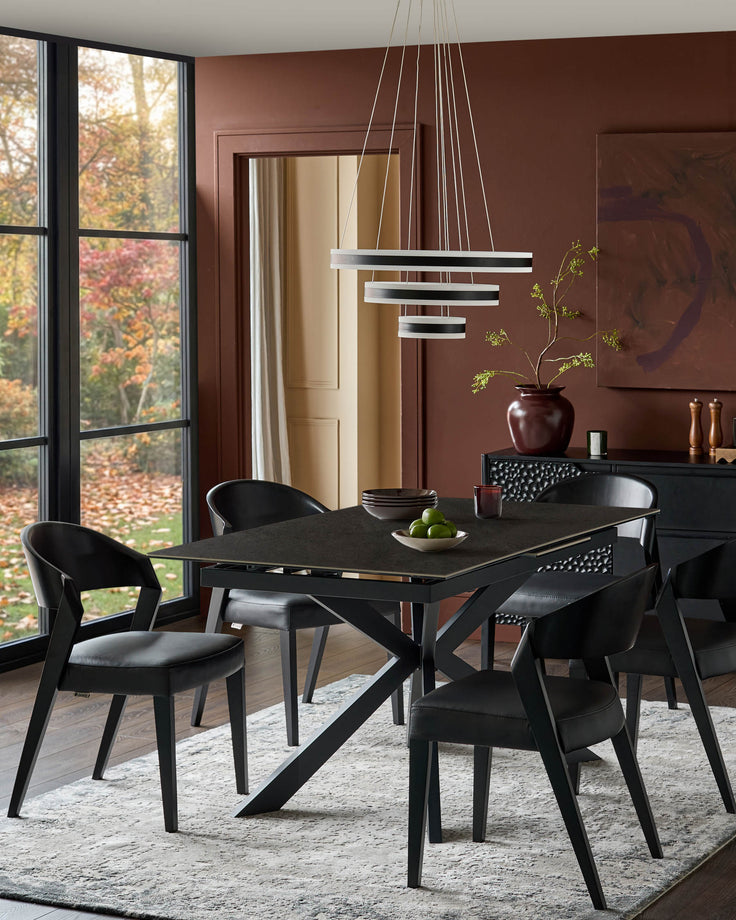 Hayden extending dining table in dark grey ceramic with black X-frame base, shown in dining room setting.
