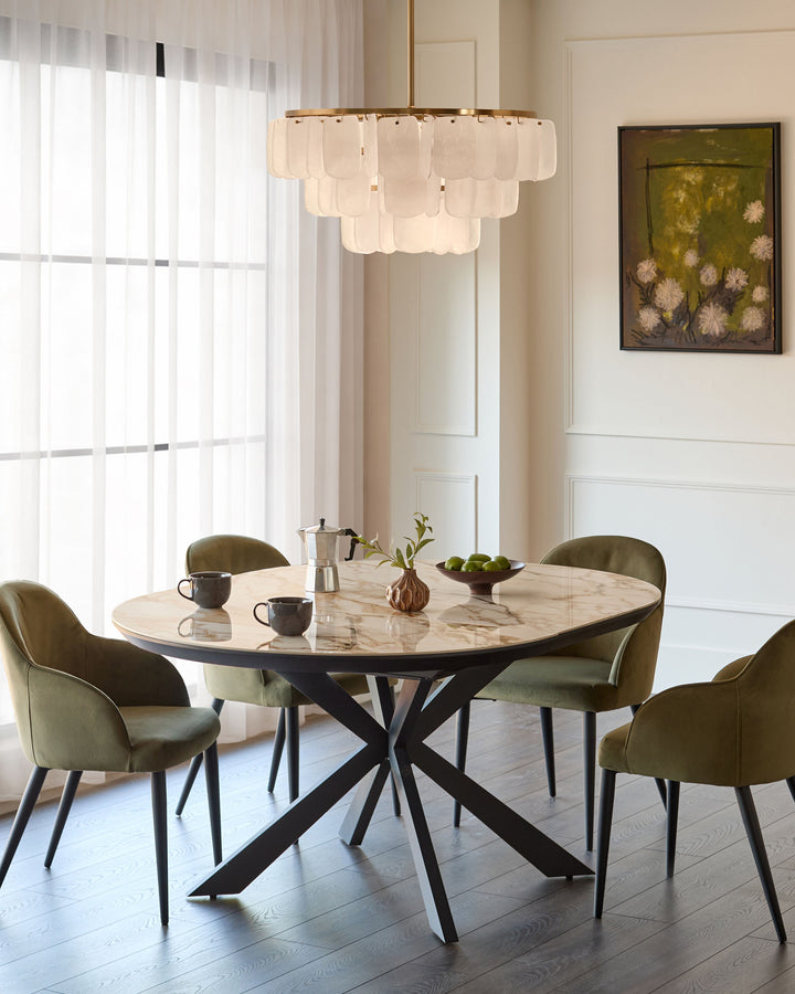 Hayden round extending dining table in natural ceramic with black metal X-frame base, styled in modern dining room.