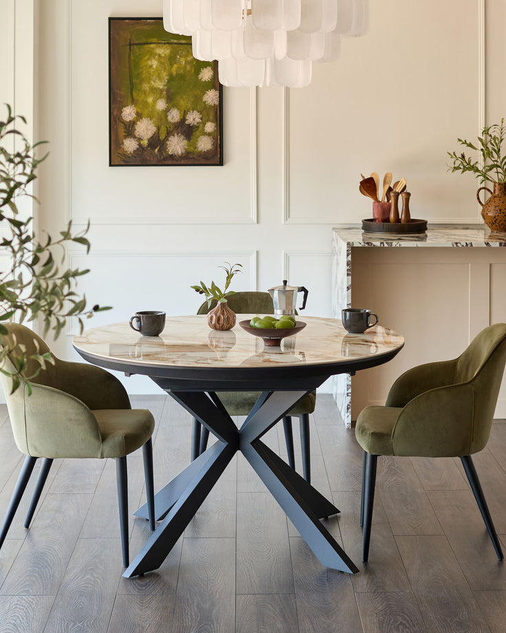 Hayden round extending dining table in natural ceramic with black X-frame base, styled in modern dining room setting.