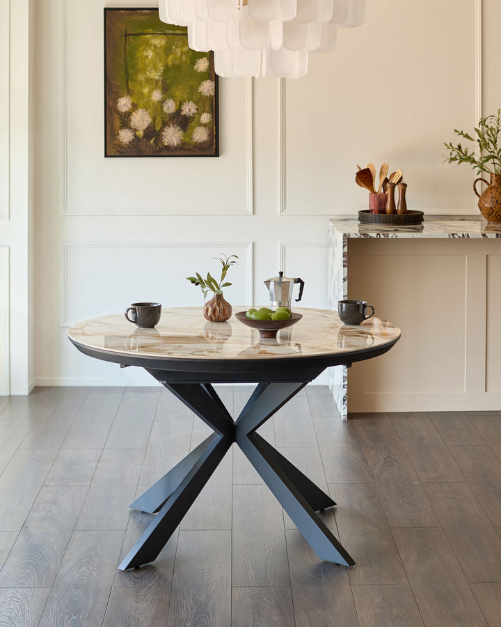 Hayden round extending dining table in natural ceramic with black metal X-frame base, styled in modern dining room.