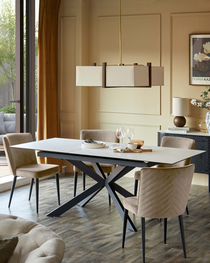 Dining space featuring a modern dining table with grey legs, velvet chairs, and a cabinet in the background, creating an elegant look.