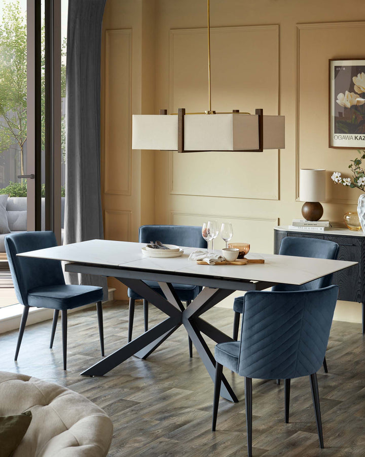 A dining room display with a white table, four blue chairs, and a modern overhead light fixture.