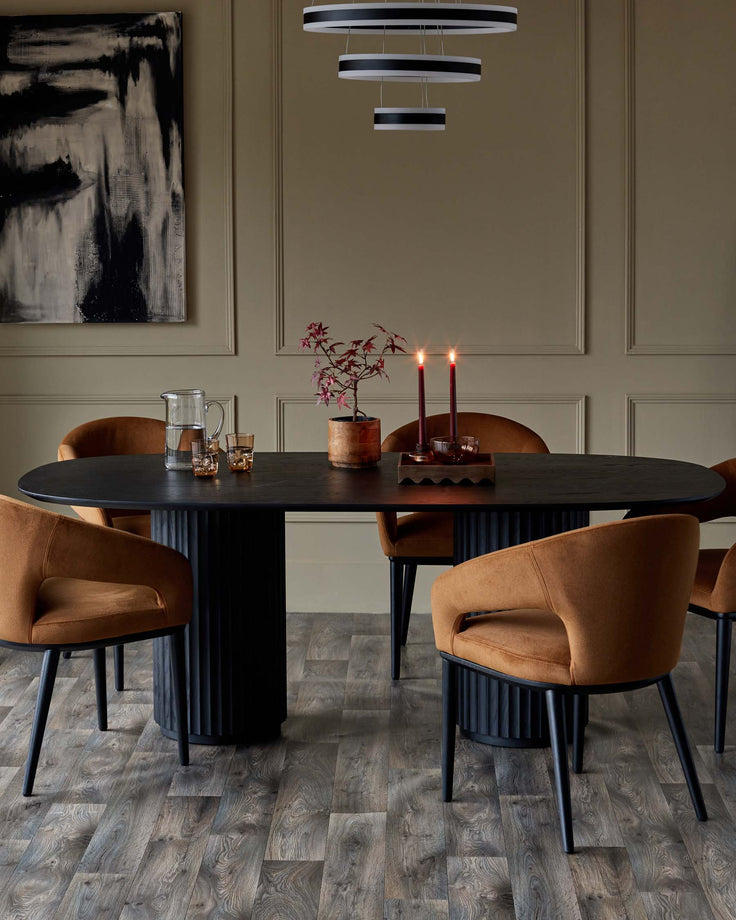 A dining set with a dark wood oval table, stylish chairs with tan fabric, and a modern light fixture.