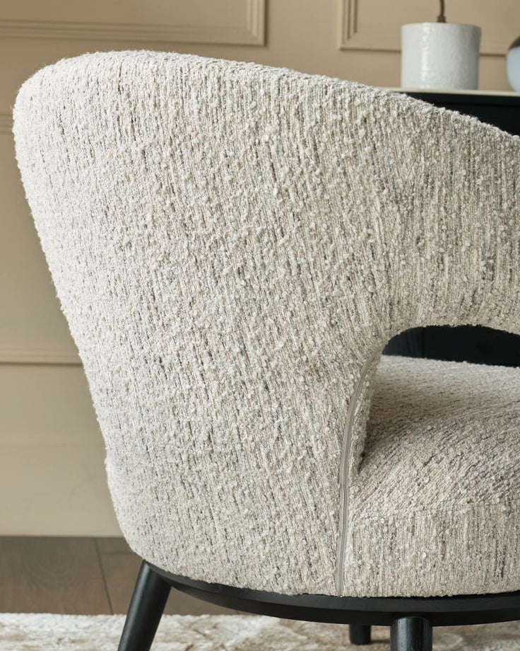 Close-up of a stylish, textured armchair with dark wooden legs, showcasing its unique design and comfort.