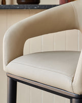 Beige bar stool with curved arms and dark wood frame. Modern design for kitchen islands and home bars.