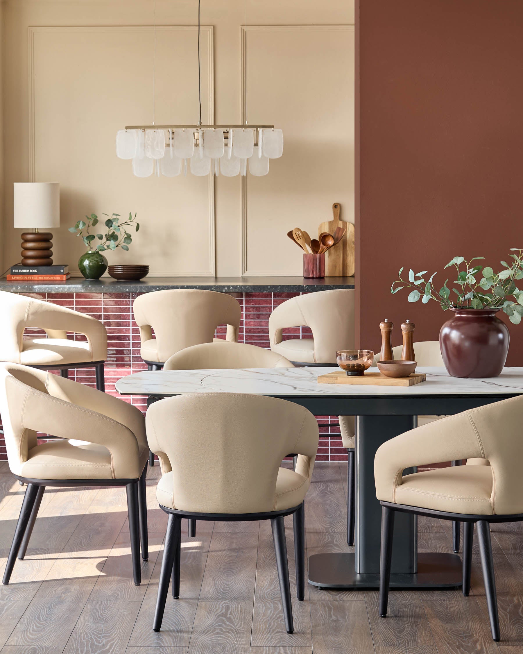 A modern dining set with a marble-effect table surrounded by six stylish chairs upholstered in a cream-coloured fabric.