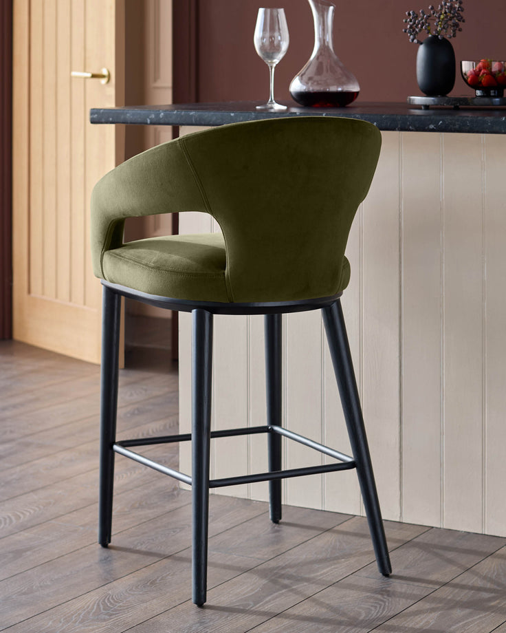 A stylish green velvet bar stool with a black frame adds a touch of elegance to any kitchen or bar area.