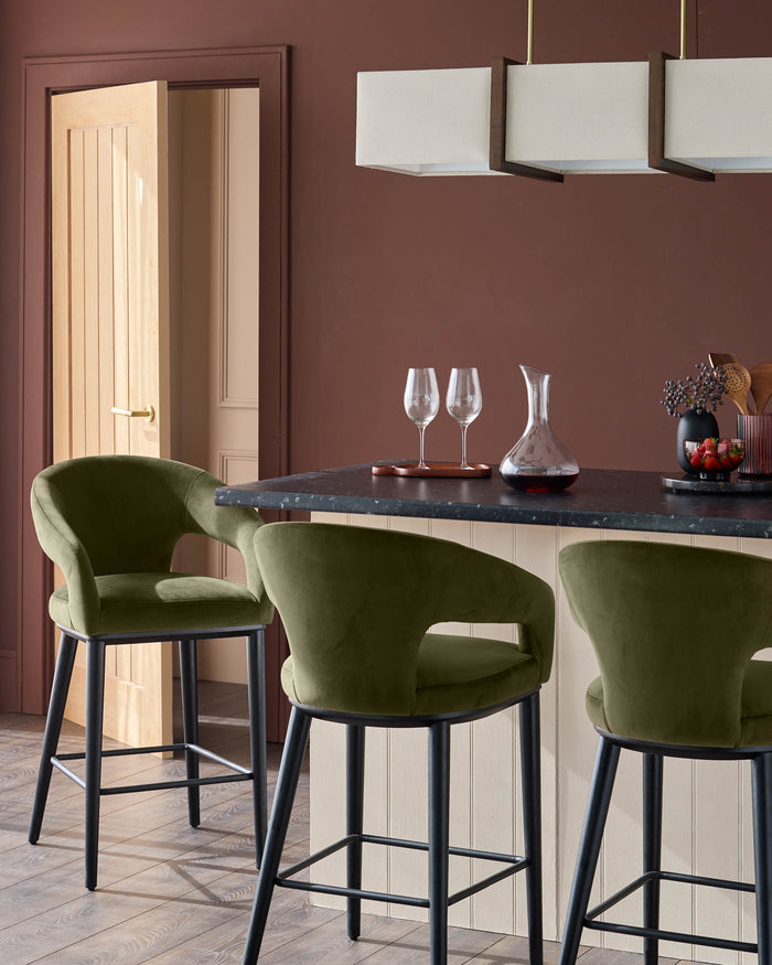 Three olive green bar stools sit at a counter in a modern kitchen. The stools have black legs.