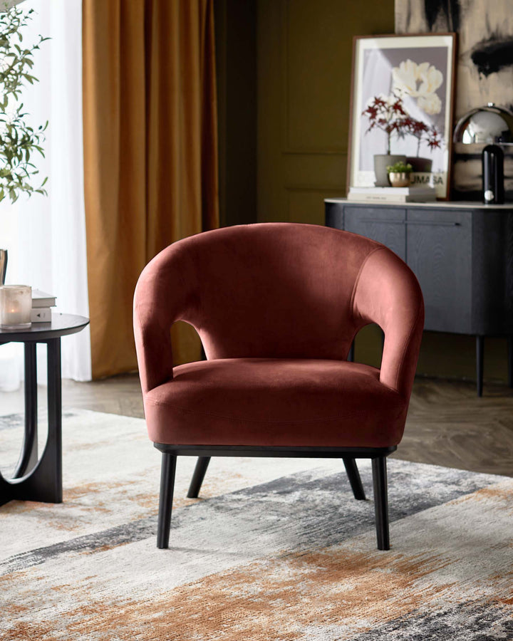 A plush, brick-red velvet armchair with a sleek black frame adds a touch of luxury to this interior setting.