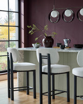 Henley blackwood bar stool in ivory fabric, shown at marble kitchen island with black frame and footrest detail.