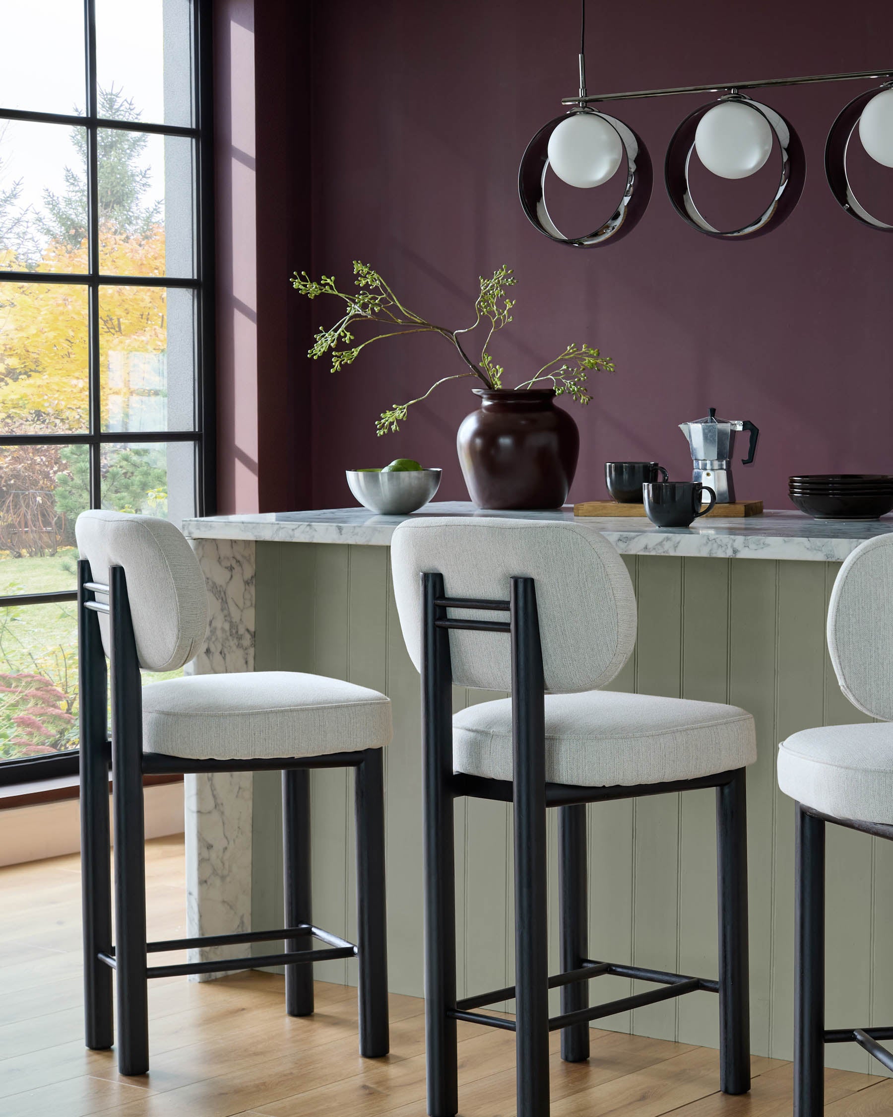 Henley blackwood bar stool in ivory fabric, shown at marble kitchen island with black frame and footrest detail.