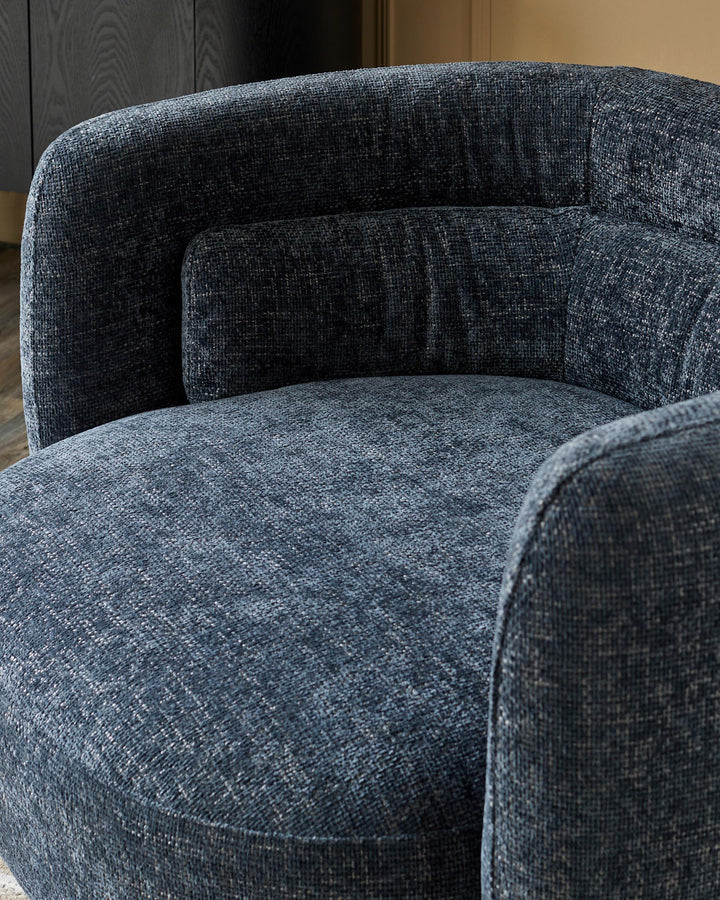 A stylish, blue upholstered armchair with a cushioned back, providing a comfy and contemporary seating solution.