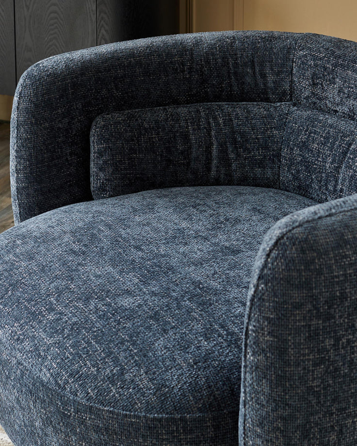 A stylish, blue upholstered armchair with a cushioned back, providing a comfy and contemporary seating solution.