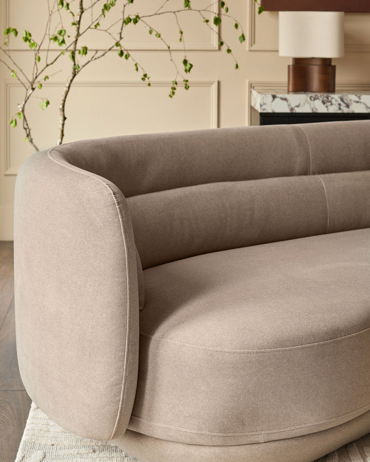 Henry 3-seater sofa in mocha fabric with curved arms and cylindrical back cushions, angled side view.
